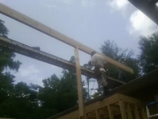 Carpenter setting a ridge beam over a new addition frame — Ice Dam Removal by Roofing Brothers in Fitchburg