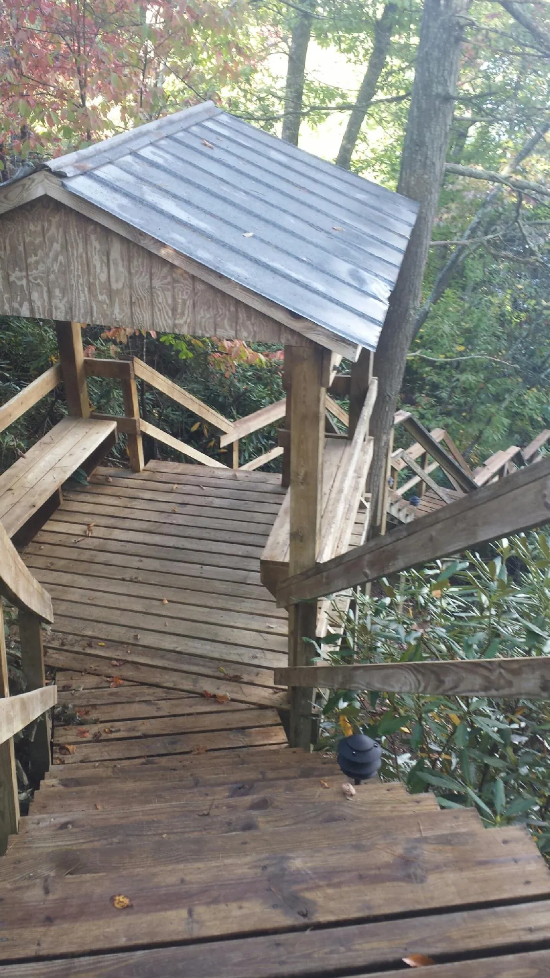 Metal roofed shelter over wooden steps on a wooded walkway — Skylight Repair & Installation work by our crew in Fitchburg