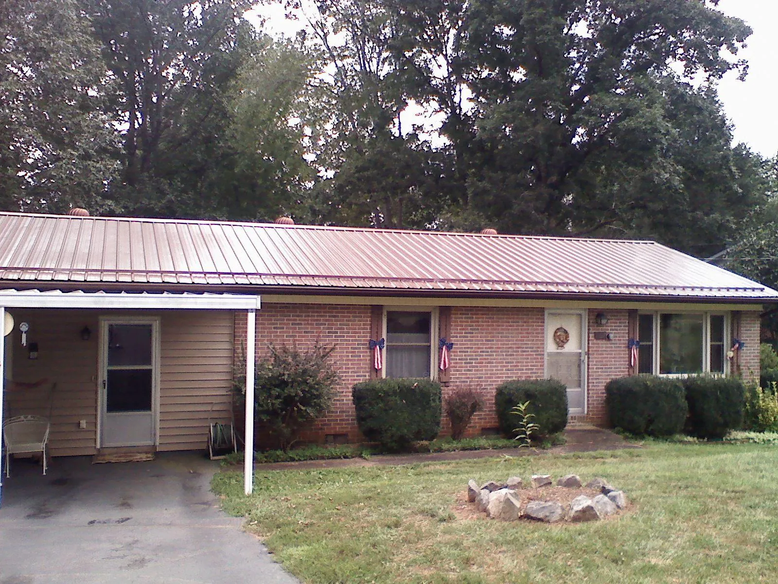 Bronze metal roof and carport on a brick ranch home — Roof Repair work by our crew in Fitchburg